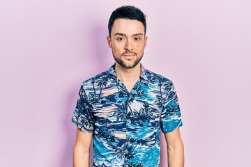 Young hispanic man wearing casual clothes with serious expression on face. simple and natural looking at the camera.