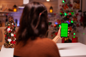 Festive person holding smartphone with green screen for modern technology on mockup template....