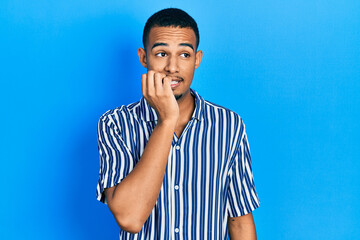 Young african american man wearing casual clothes looking stressed and nervous with hands on mouth biting nails. anxiety problem.