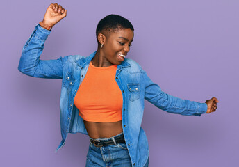 Young african american woman wearing casual clothes dancing happy and cheerful, smiling moving...