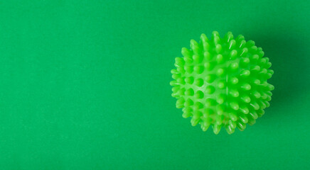 Green laundry ball for washing machine on vibrant green background. Copy space