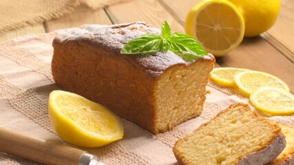 Lemon pound cake on rustic wooden background with lemon and mint.