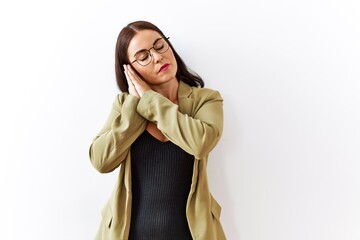 Young brunette woman standing over isolated background sleeping tired dreaming and posing with hands together while smiling with closed eyes.