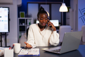 Stressed exhausted african american businesswoman talking with manager at phone discussing anuual...