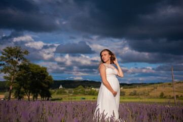 Beautiful smiling pregnant woman on the field