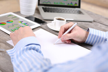 business, education, people and technology concept - male hands with laptop computer, notebook and pen taking notes