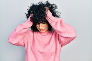 Young middle east woman wearing casual clothes suffering from headache desperate and stressed because pain and migraine. hands on head.