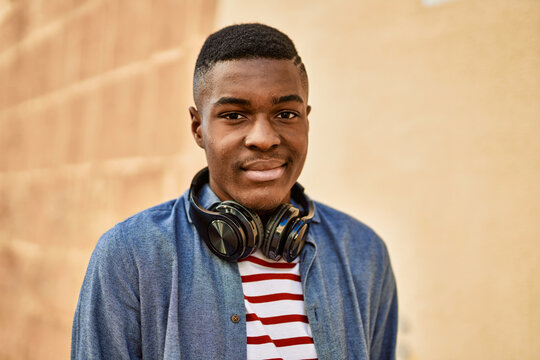 Young african american man with relaxed expression using headphones at the city.