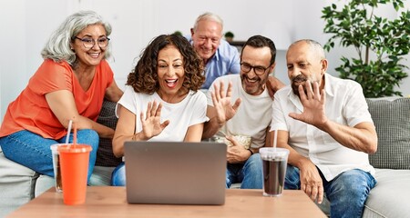 Group of middle age friends having video call using laptop at home.