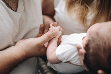 Hand of a newborn baby. The baby in the parents arms. Mom with a newborn.