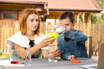 Mom and son are conducting chemical experiments at home. An experience with a child about creating a rocket launcher using a bottle, soda and vinegar.
