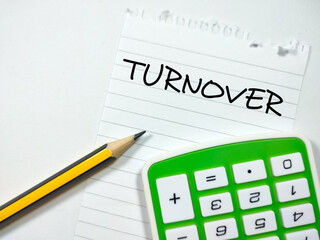 Business concept.Text TURNOVER writing on notepaper with pencil and calculator on white background.