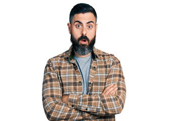 Hispanic man with beard with arms crossed gesture afraid and shocked with surprise and amazed expression, fear and excited face.