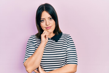 Fototapeta premium Young hispanic woman wearing casual clothes looking confident at the camera with smile with crossed arms and hand raised on chin. thinking positive.