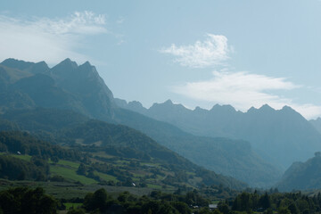 Obraz premium Layered mountain landscape backlit by sun on distance with haze. Lescun, Pyrenees mountains, France