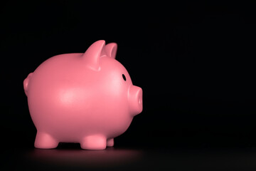 Pink Piggy bank horizontal on black background with copy space, business,savings and financial...