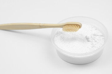 Bamboo toothbrush and tooth powder on a white background. Eco-friendly oral care