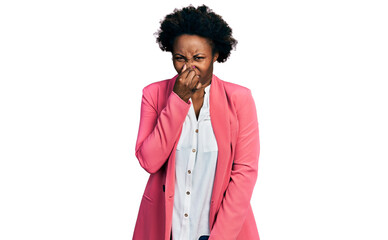 African american woman with afro hair wearing business jacket smelling something stinky and...