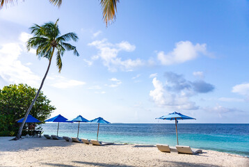 Maldive luxury beach chairs with clear sea water blue sky and coconut tree