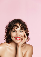 Beauty face. Smiling curly teen girl touching healthy skin portrait. Beautiful happy woman model...