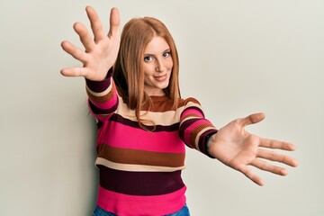 Fototapeta premium Young irish woman wearing casual clothes looking at the camera smiling with open arms for hug. cheerful expression embracing happiness.