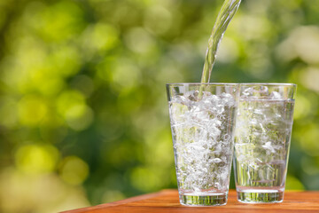 drinking pouring into glass with ice cubes