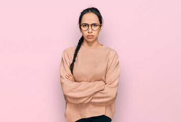 Young hispanic girl wearing casual clothes and glasses skeptic and nervous, disapproving expression...