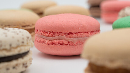 Multiple flavor Cake macaron or macaroon on turquoise macros on a white background.