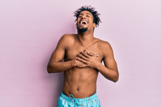 Young african american man with beard wearing swimsuit smiling with hands on chest with closed eyes and grateful gesture on face. health concept.