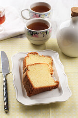 Slice of Fluffly Vanilla Chiffon Cake or Sponge Cake on Wooden Plate, Served with Tea and Honey. Bright Food Photography Concept for Bakery. Selected Focus
