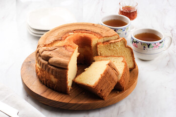 Slice of Fluffly Vanilla Chiffon Cake or Sponge Cake on Wooden Plate, Served with Tea and Honey....