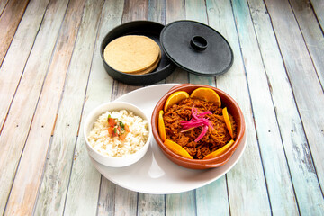 Mexican cochinita pibil stew accompanied by white rice with pico de gallo and corn tortillas to prepare some delicious tacos