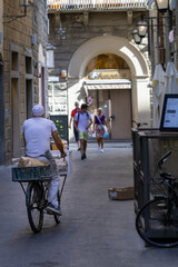 Der B&auml;cker f&auml;hrt auf einem Fahrrad. Auf dem Gep&auml;cktr&auml;ger liegt in Papier eingewickeltes Geb&auml;ck. 
