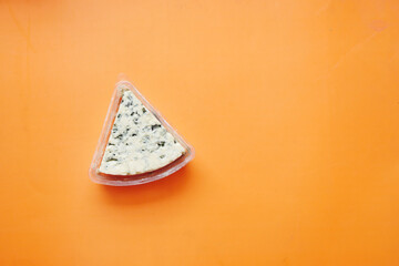 top view of blue cheese on orange background 