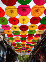 Fototapeta na wymiar The Colorful umbrellas Street decoration, floating above the walking street at Chiang Mai, Thailand.