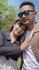 Fototapeta premium happy young couple leaning on each other in spring park