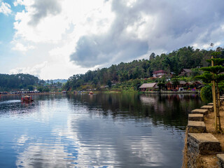 Fototapeta premium The beautiful lake and house reflection on the water at Ban Ruk Thai, which Yunnan Chinese Village at Mae Hong Son, Thailand.