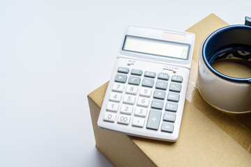 梱包されたダンボール箱と電卓