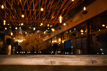 Fototapeta na wymiar empty wooden table on blurred light gold bokeh cafe restaurant bar, place for your products on the table.