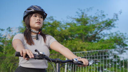 Obraz premium young asian woman enjoying cycling in summer morning