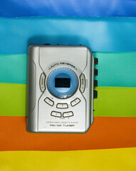 picture of silver color portable cassette player in rainbow colored background.