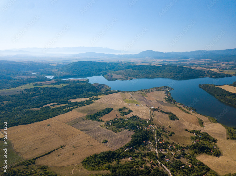 Wall mural Aerial view of a blue lake, agricultural fields and mountains under a blue clear sky