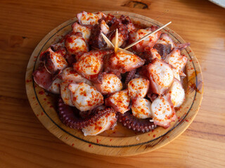 Pulpo a la gallega in Spanish meaning Galician-style octopus served on the wooden plate.