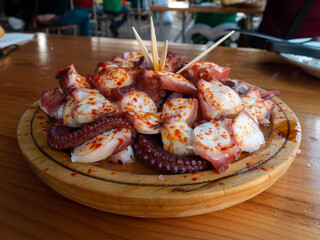 Pulpo a la gallega in Spanish meaning Galician-style octopus a traditional Galician dish served on the wooden plate.