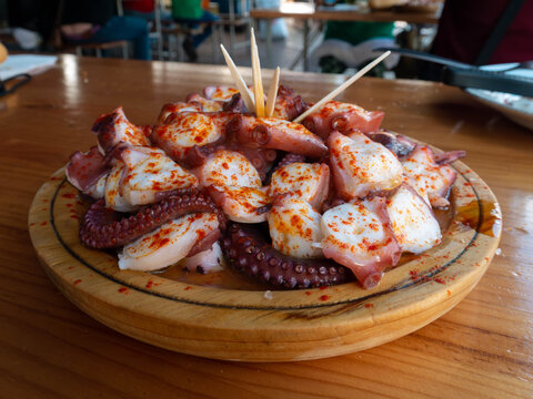 Pulpo a la gallega in Spanish meaning Galician-style octopus a traditional Galician dish served on the wooden plate.