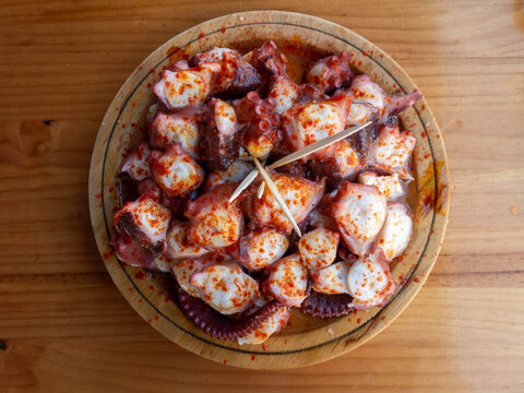Galician-style octopus a traditional Galician dish served on the wooden plate top view.