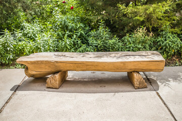 a rustic-style bench made of halved logs with log legs. most often serves in parks outside the city...