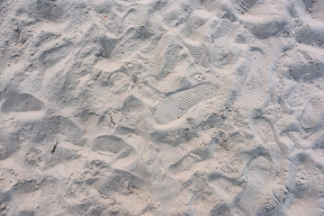 Different shoe prints in light sand designed for beach volleyball.