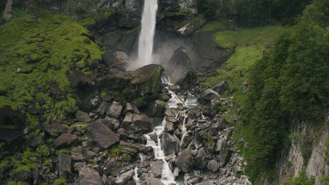 Aerial view of an incredible steep waterfall surrounded by the lush vegetation of the forest near Cevio, Ticino, Switzerland.