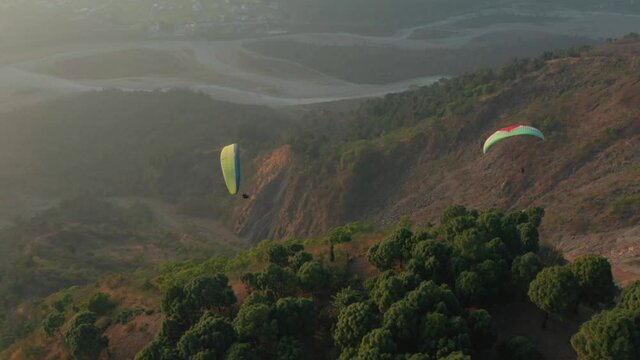 Aerial view of people flying with parachuting above a beautiful valley in Poraia, Jharkhand, india.